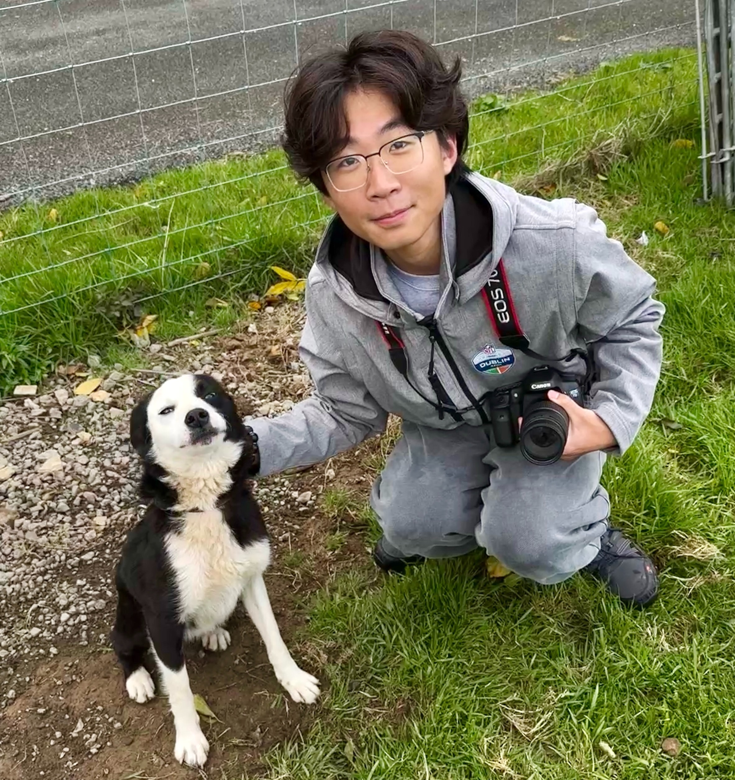 Student kneeling beside shepherd dog